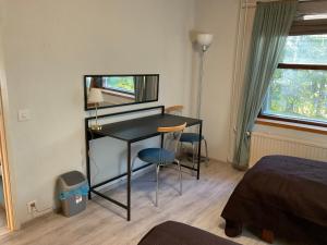 a room with a desk and a bed and a mirror at Revontuli Apartments in Rovaniemi