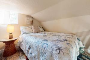 a small bedroom with a bed and a table at Bunglow Boogie Bunkhouse in New Port Richey