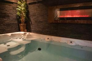 a large bath tub in a bathroom with aburning at Suite Wellness in Sprimont