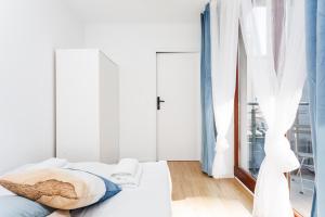 een witte slaapkamer met een bed en een raam bij Pretty 4 Bedroom Apartment x Parking Spot x City Center in Krakau