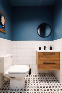 een badkamer met een toilet, een wastafel en een spiegel bij Pretty 4 Bedroom Apartment x Parking Spot x City Center in Krakau