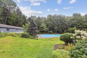 un patio con piscina y una casa en Tollhouse 16B, en Stowe