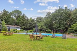 a group of chairs and umbrellas next to a pool at Tollhouse 16B in Stowe