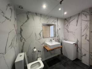 a bathroom with a sink and a toilet and a mirror at Avli Luxury Apartment in Ierissos +14 photos