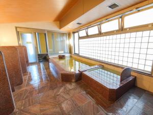 una sala de espera con sillas, mesa y ventanas en APA Hotel Takasaki Ekimae, en Takasaki