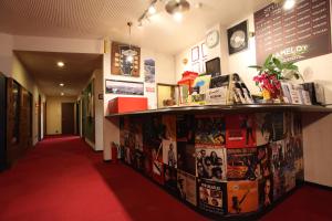 una camera con tappeto rosso e mensola con film di Hotel Camelot a Fujikawaguchiko