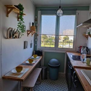 una cucina con tavolo, lavandino e finestra di Terrasse+parking 3 BR6P-Paris near stade de France a Saint-Denis