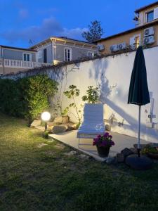 een patio met een stoel en een parasol in de tuin bij At Fourth in Cagliari