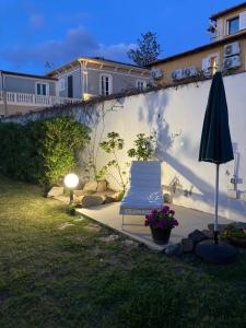 a patio with a chair and an umbrella in a yard at At Fourth in Cagliari