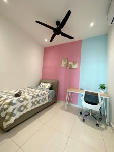 urban sea view home 2bed studio في ماساي: غرفة نوم مع سرير ومكتب ومروحة سقف
