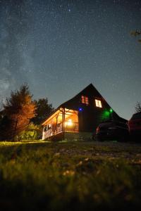 a house lit up at night with a starry sky at Urocza chata z sauną w bieszczadzkim Parku Krajobrazowym in Bukowiec