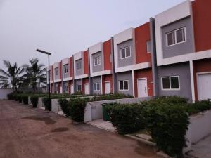 una fila de edificios de apartamentos en un estacionamiento en Dolly House, en Tema