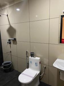 a bathroom with a toilet and a sink at Redbell Suites Kizhisseri in Kondotti