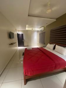 a bedroom with a large red bed in a room at Redbell Suites Kizhisseri in Kondotti