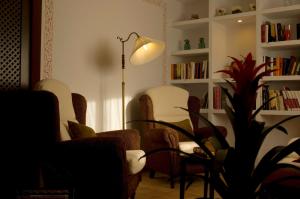 sala de estar con sillas, mesa y lámpara en La Posada De Santa Ana en Tramacastilla