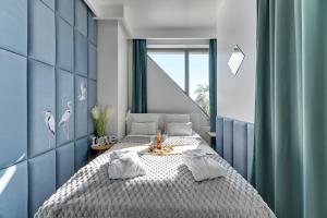 Dormitorio azul y blanco con cama y ventana en GRANARIA Kingdom & Happiness Premium Apartments by the River en Gdansk