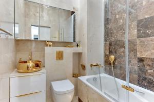 een badkamer met een bad, een toilet en een wastafel bij GRANARIA Kingdom & Happiness Premium Apartments by the River in Gdańsk