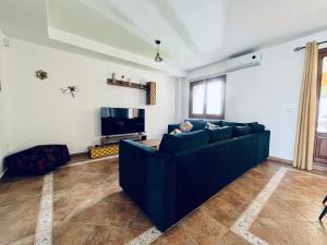 sala de estar con sofá azul y TV en Lomas 62, en Ayamonte