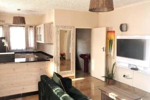 a living room with a couch and a kitchen at Gorgeous 1-Bed apartment in Harare in Harare