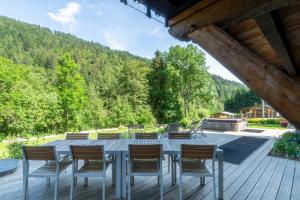 a table and chairs on a deck with a view at Ferme Liberté - stunning, comfortable, & modern sleeps 14- private mini van in Les Gets