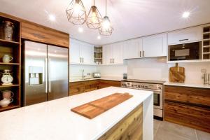 a kitchen with white cabinets and a stainless steel refrigerator at Ferme Liberté - stunning, comfortable, & modern sleeps 14- private mini van in Les Gets