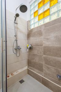 La salle de bains est pourvue d'une douche avec une porte en verre. dans l'établissement Alimos Marina Beach Apartment, à Athènes
