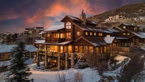 Casa de madera grande con nieve en el suelo en Chalet Beliza, en Steamboat Springs