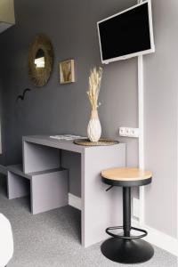 escritorio con silla y TV en la pared en Diu Biban en Hossegor