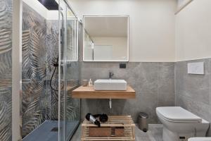 Casa RIGOLA by Apartments To Art في فيناريا ريالي: حمام مع حوض ومرآة