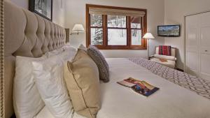 een slaapkamer met een groot wit bed met een boek erop bij Chalet Premio in Beaver Creek