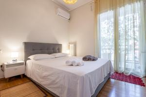 ein Schlafzimmer mit einem weißen Bett und Handtüchern darauf in der Unterkunft Alimos Marina Beach Apartment in Athen