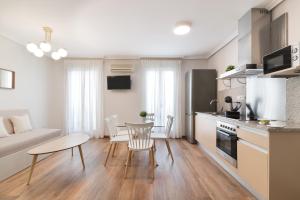 cocina y sala de estar con mesa y sofá en Roisa Centro en Madrid