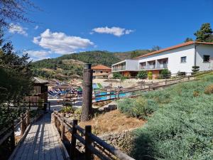 a house with a wooden fence next to a street at Douro Cister Hotel Resort in Ucanha