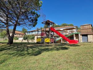 un parque infantil frente a un edificio con un tobogán rojo en Douro Cister Hotel Resort en Ucanha