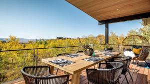 a patio with a table and chairs on a deck at Chalet Cascada in Steamboat Springs