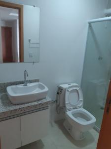 a bathroom with a sink and a toilet and a mirror at Apto frente mar 3 suites Castelhanos ES in Anchieta
