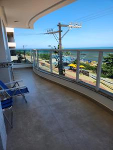 a room with a balcony with a view of a beach at Apto frente mar 3 suites Castelhanos ES in Anchieta