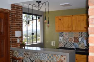 a kitchen with a counter top and a window at Chalés Estrada Real in Conceição da Ibitipoca