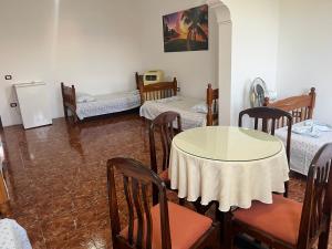 a room with a table and chairs and a room with beds at Villa Kasa in Durrës