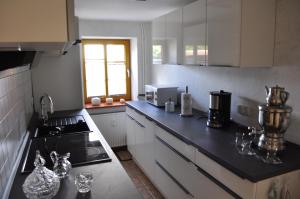 eine Küche mit weißen Schränken und einer schwarzen Arbeitsplatte in der Unterkunft Ferien/Monteurwohnung Volling in Lengede