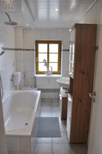 een witte badkamer met een bad en een wastafel bij Ferien/Monteurwohnung Volling in Lengede