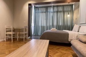 a bedroom with a bed and a couch and a table at Central Studio in Myslym Shyri Street in Tirana
