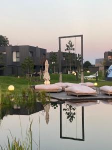 a view of a pond with pink pillows and a mirror at GOLD apartment / Mano jūra 3 in Kunigiškiai