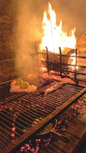 Una parrilla con comida con fuego. en Tacheles, en José Ignacio