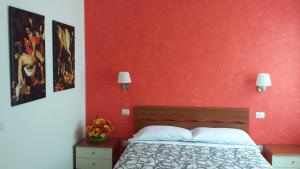 a bedroom with a bed and a red wall at Luci A San Siro in Milan