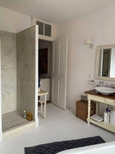 uma casa de banho branca com um lavatório e um espelho em Maison Serpolette - maison entiere em Trouville-sur-Mer