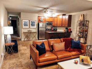 uma sala de estar com um sofá castanho e uma cozinha em Lakefront Oasis em Hot Springs