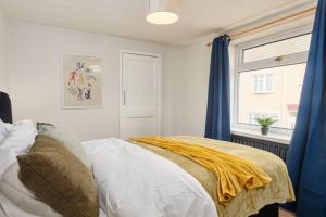 una camera da letto con un letto con tende blu e una finestra di Comfortable house by the coast a Redcar