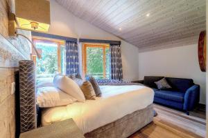 ein Schlafzimmer mit einem großen Bett und einem blauen Sofa in der Unterkunft Luxury Chalet Espoir in Montriond