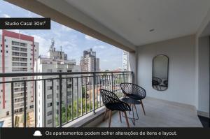 a balcony with two chairs and a view of a city at House of Charlie Paraiso in Sao Paulo